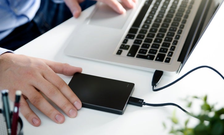Hombre utilizando un disco duro externo