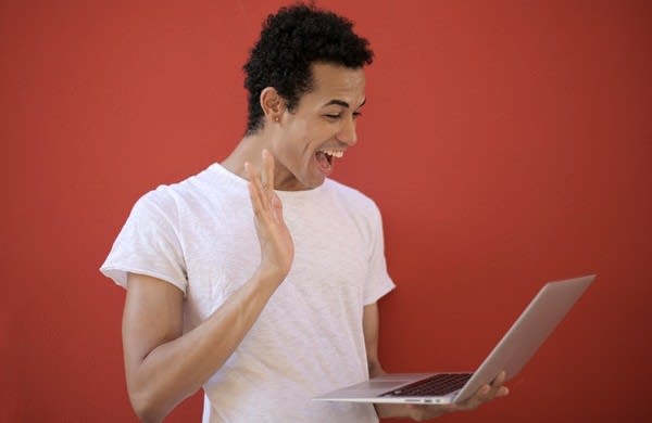 Hombre saludando a un portátil
