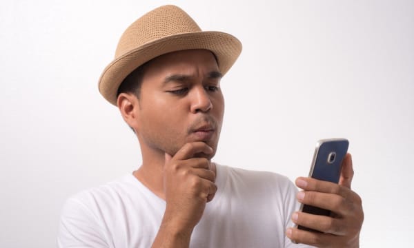 Hombre con sombrero utilizando móvil