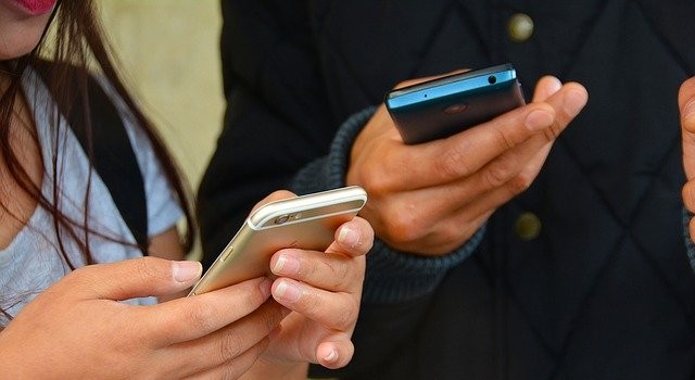 Jóvenes utilizando su teléfono móvil