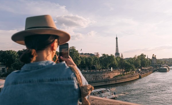 Chica fotografiando la Torre Eiffel