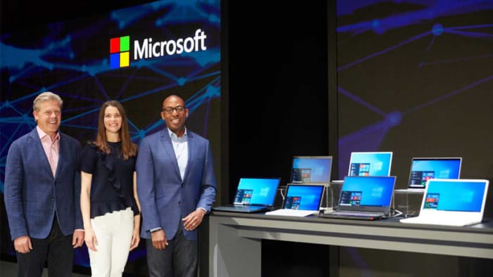 Microsoft execs in front of Windows PCs