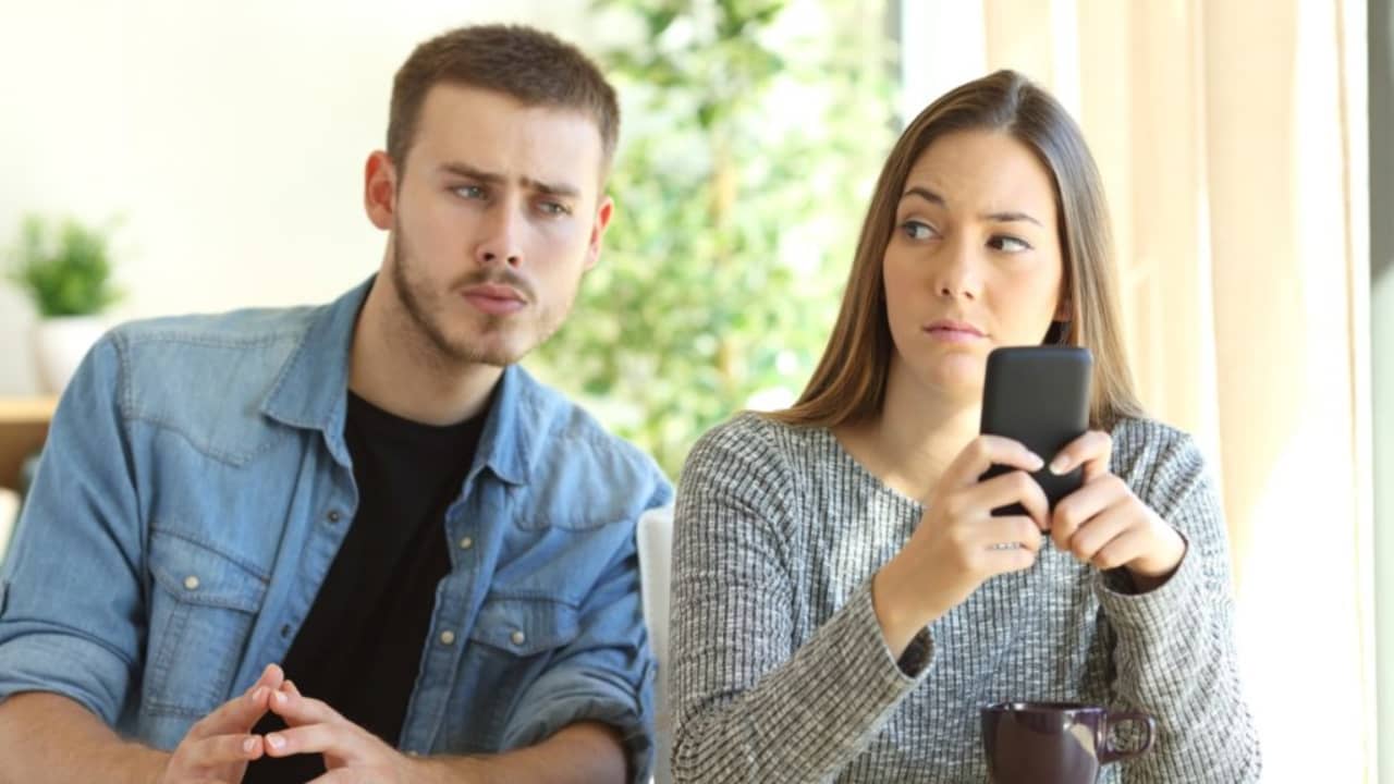 Novio espiando el móvil de su pareja