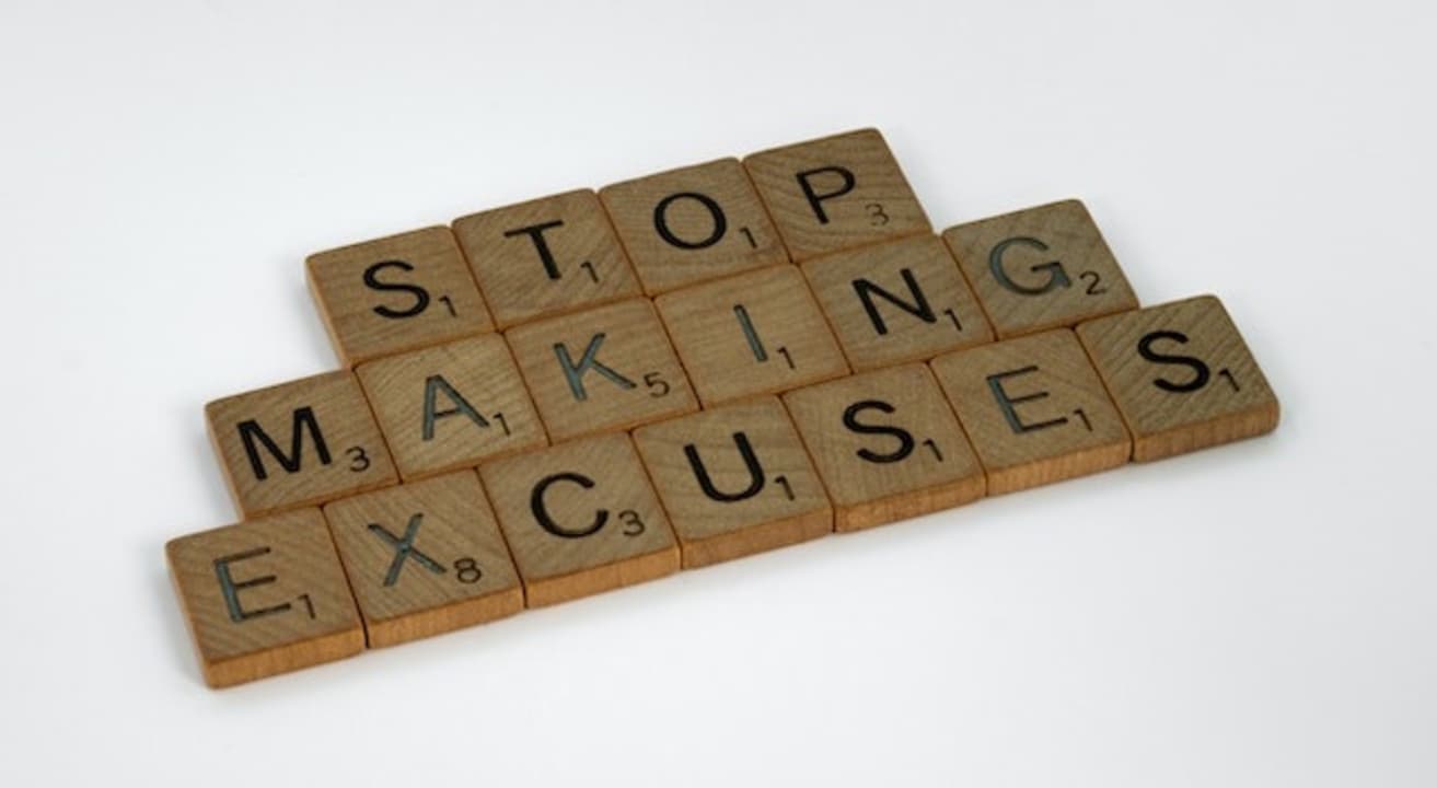 Piezas de Scrabble con el mensaje "Stop making excuses"